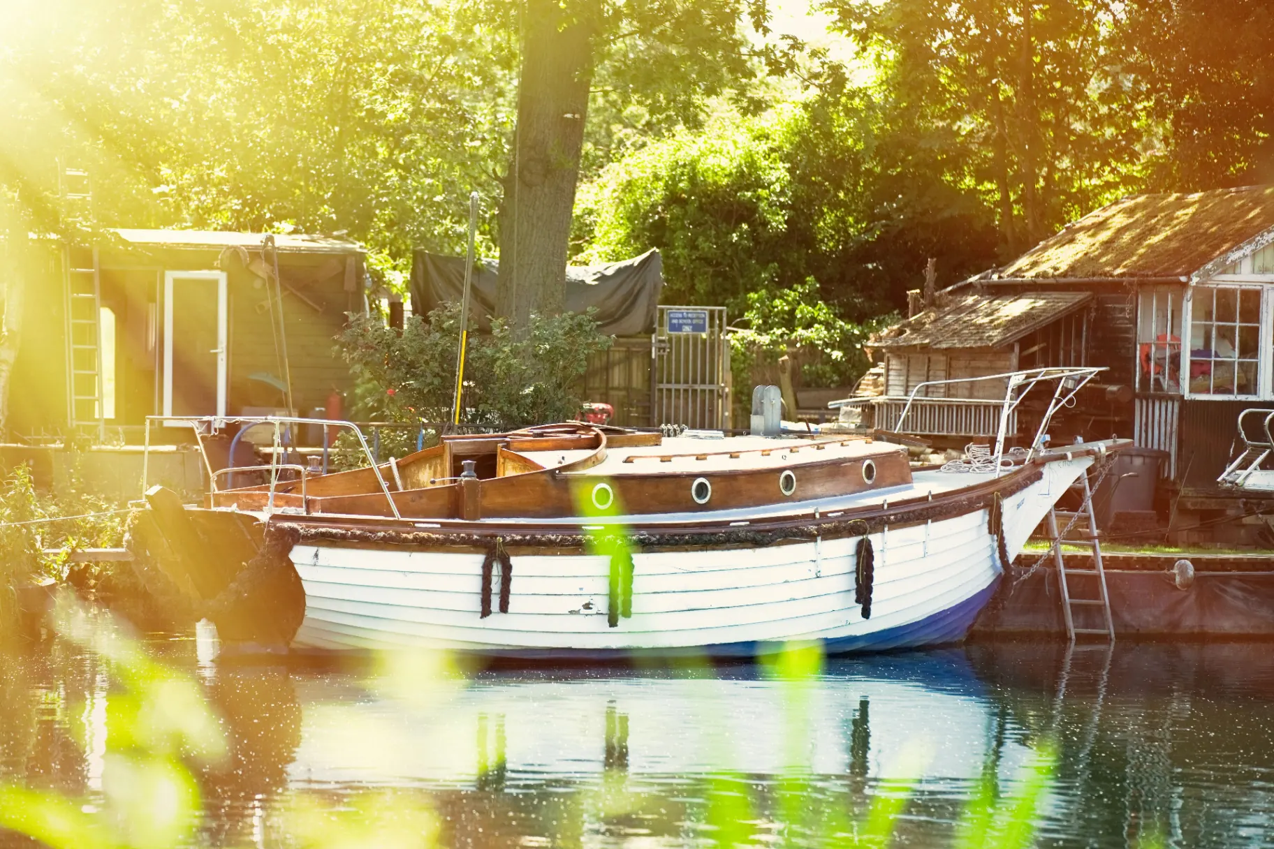 Classic wooden boat moored on a sunlit Thames riverside in spring